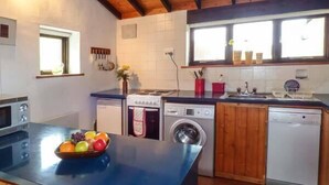 Una cocina compacta con estufa, horno, lavadora y lavavajillas.