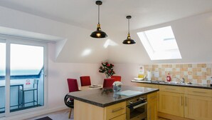 A modern kitchen with wooden cabinets, a central island, and pendant lighting.
