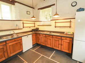 A kitchen with wooden cabinets, a dishwasher, a stove, and a refrigerator.