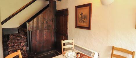 A dining area with a wooden table set for four, including plates, cutlery, and glasses.