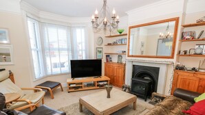A cozy living room with a fireplace, a television, and comfortable seating. - Dovedale (Ryde)