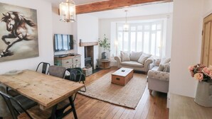 Un salon chaleureux avec une table à manger en bois, un canapé, une table basse et une cheminée.