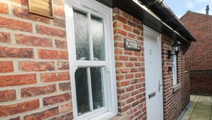 A brick building with a white door and a window. There is a sign above the door that reads "PLATFORM 12". - Platform 12 (Whitby)