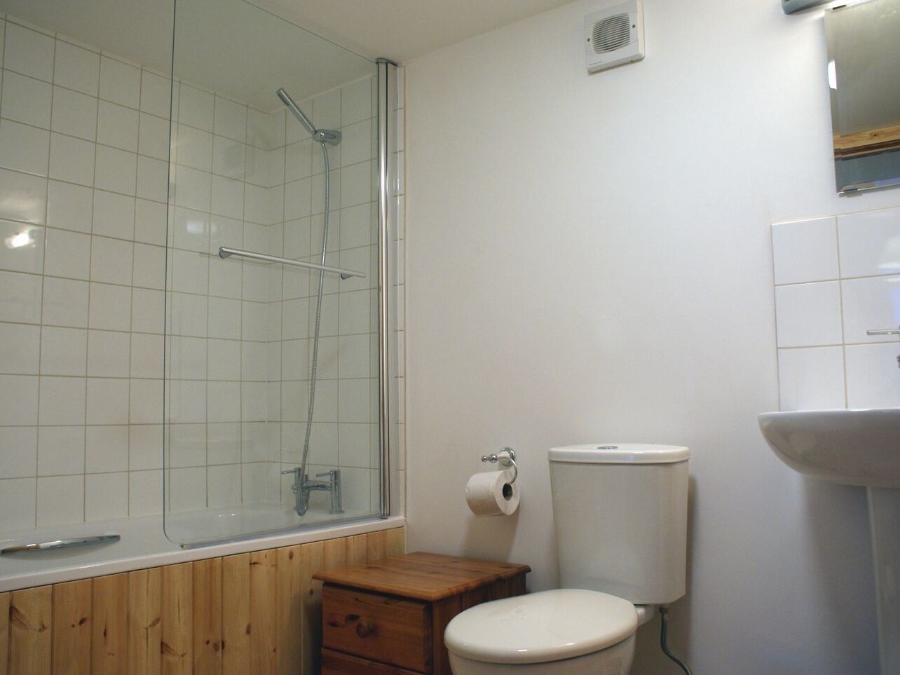 Une petite salle de bain avec une douche, des toilettes et un lavabo.