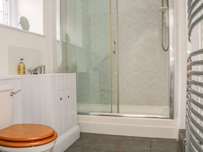 A bathroom with a toilet, sink, and glass-enclosed shower.