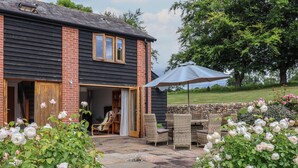 A house with a patio area featuring outdoor furniture and a stone wall.