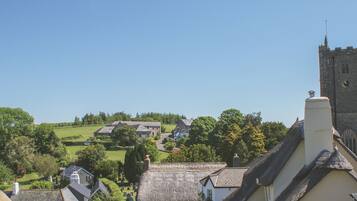 A village with traditional thatched-roof houses, a church, and a prominent tower.