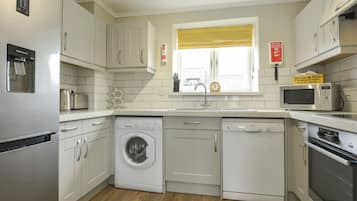 Enjoy cooking and cleaning in this well-equipped kitchen with a refrigerator, microwave, oven, dishwasher, and washing machine.