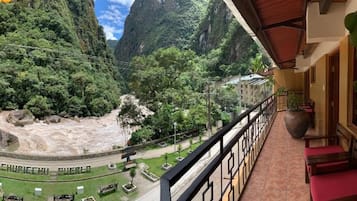 Un balcon offrant une vue sur un paysage montagneux et une route sur laquelle on peut lire un panneau indiquant « MASHUPICHEHU CHERET ».