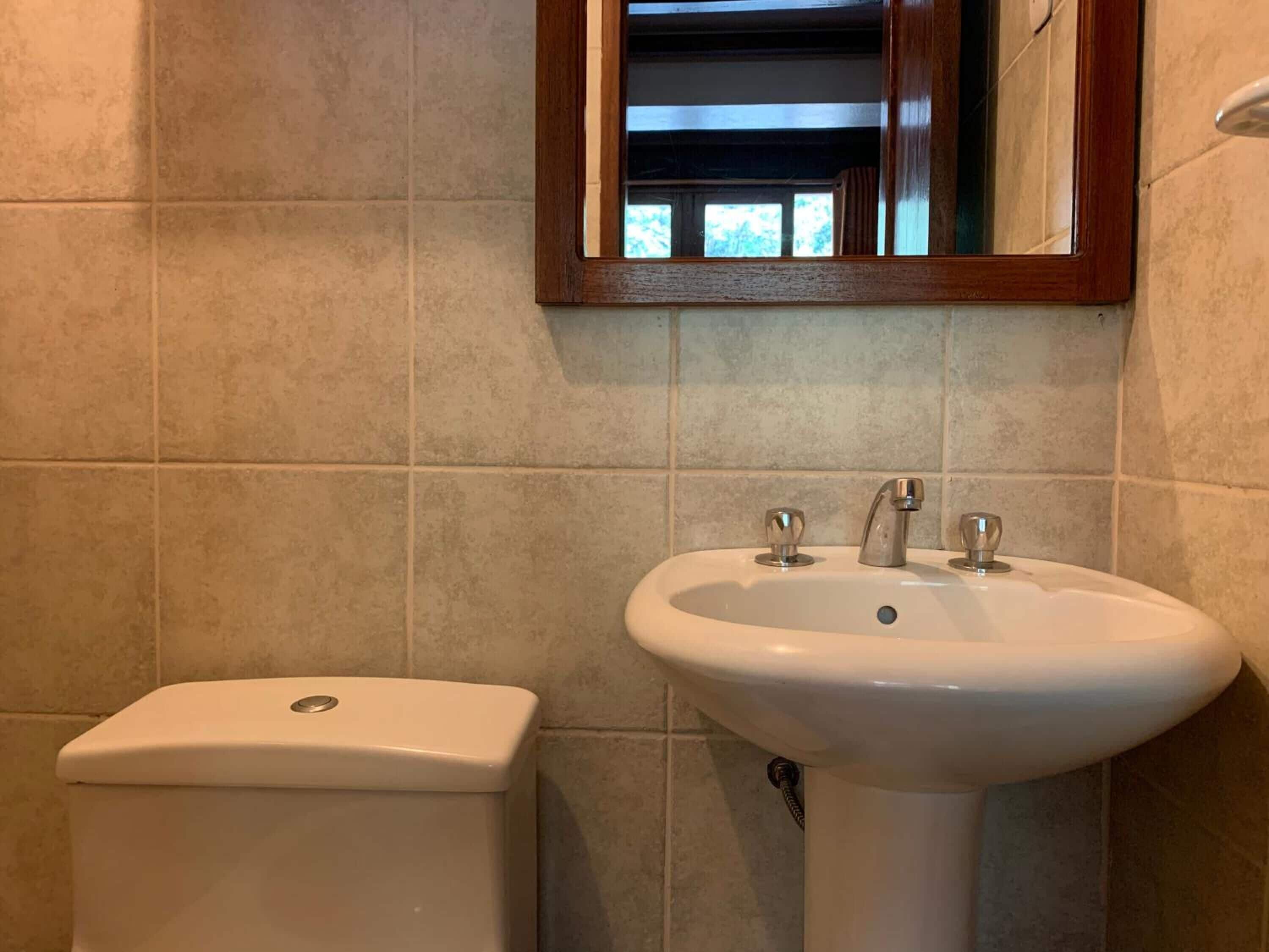 Une salle de bain avec des toilettes et un lavabo.
