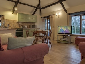 Relax in a cozy living space with a comfortable seating area, dining table, and mounted TV.