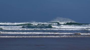 A beach with waves and a clear sky.