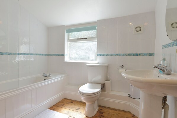 A bathroom with a bathtub, toilet, and sink. - April Cottage (Helston)