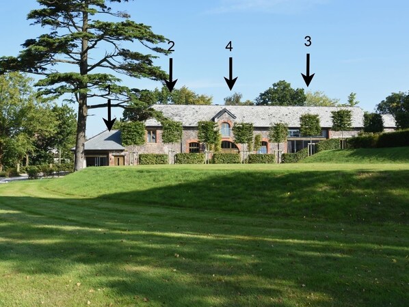 A building with a stone facade, multiple windows, and a sloped roof.