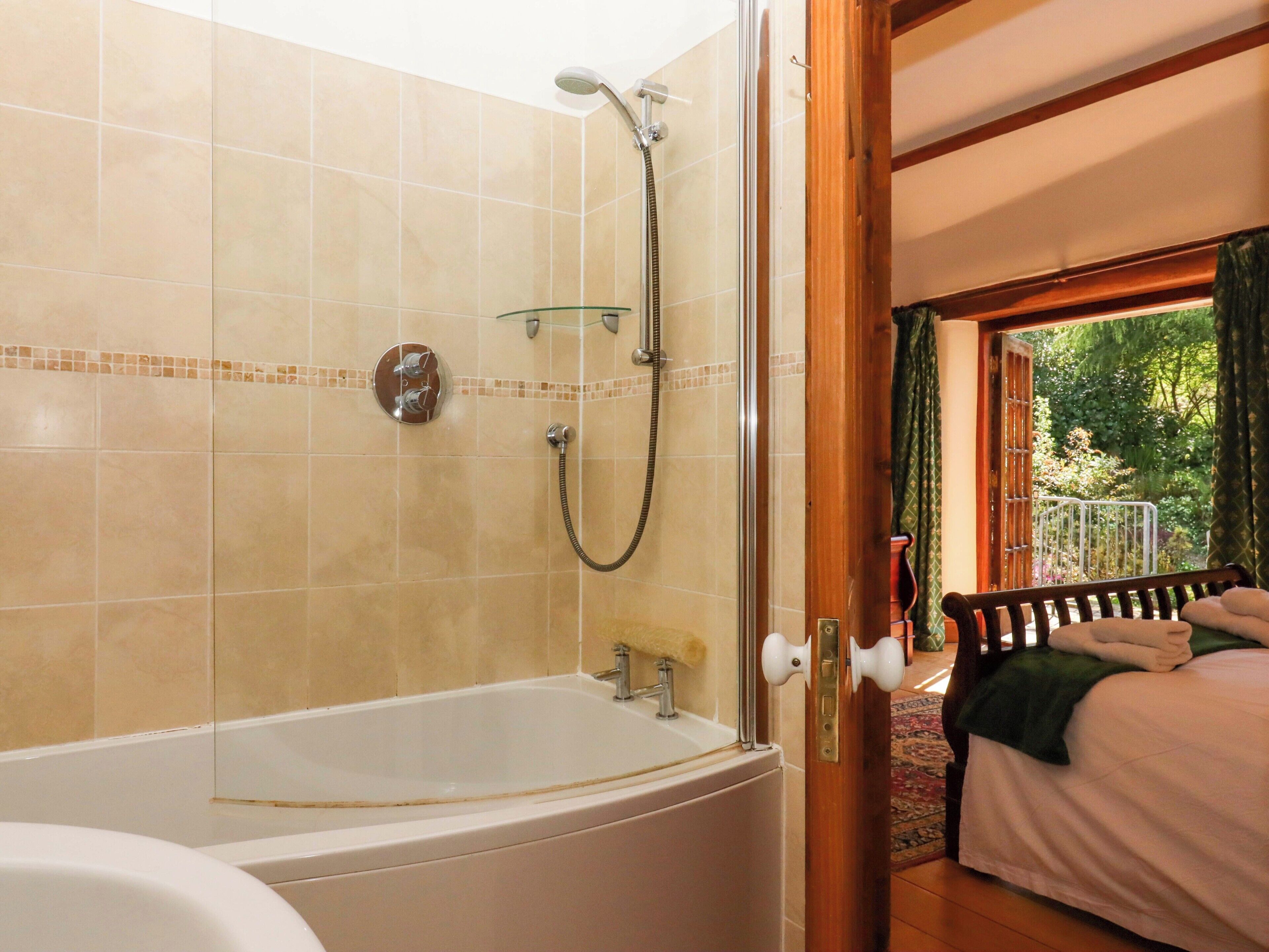 A bathroom with a bathtub, shower, and glass-enclosed shower area.