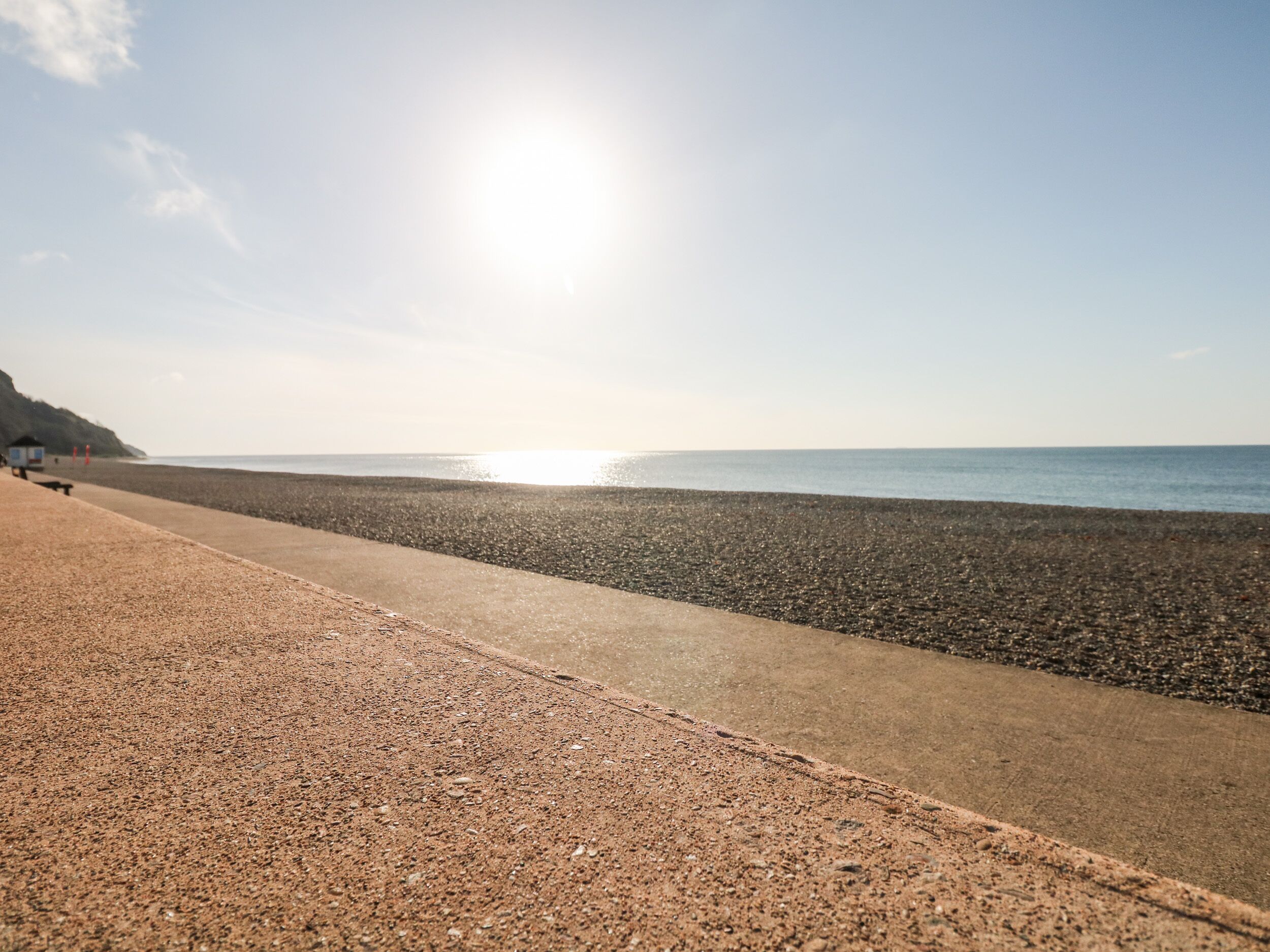 Une plage au rivage de galets et sous un ciel dégagé.