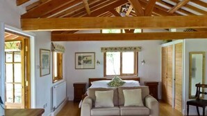 A room with a wooden ceiling, a sofa, a bed, and a window. - The Springs (Ryde)