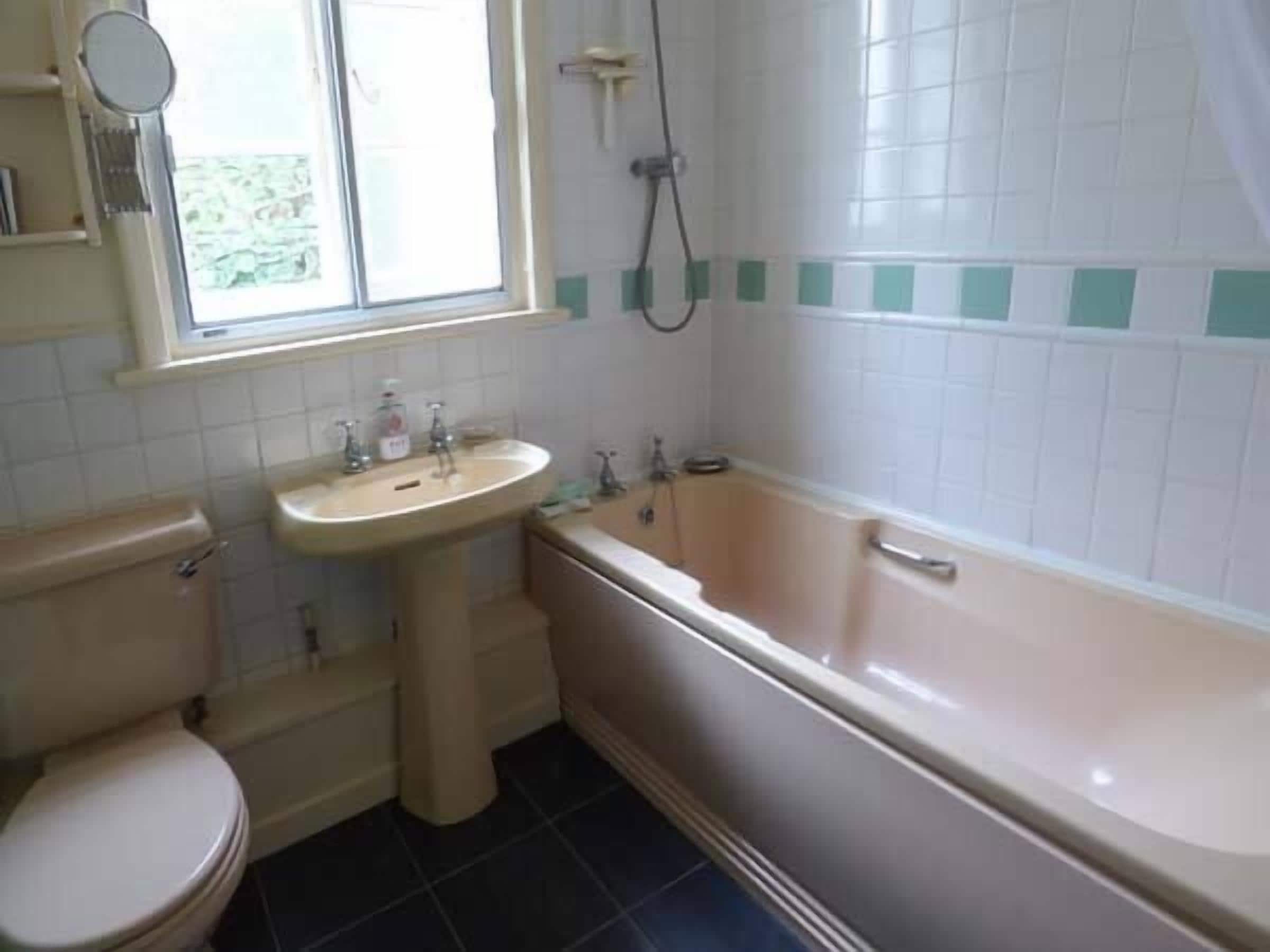 A bathroom with a toilet, sink, and bathtub.