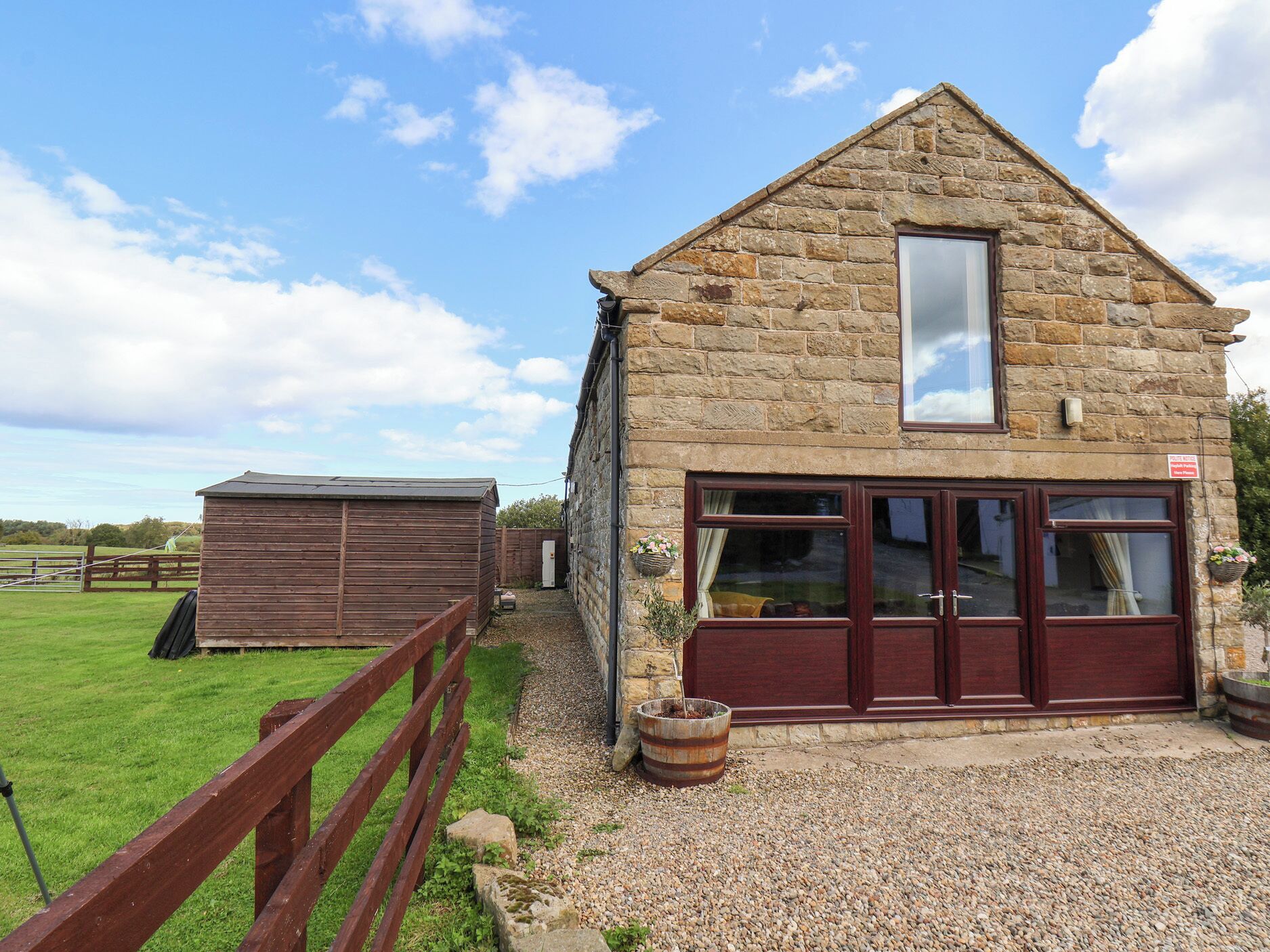 En bygning i sten med et stort vindue og en trædør.