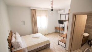 A modern bedroom with a wooden bed, a desk, and a built-in wardrobe. - Casa Luxury Suites (Kassandra)