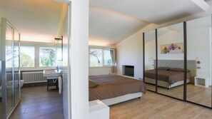 Relax in this serene space with a large bed, TV, and cozy seating area.