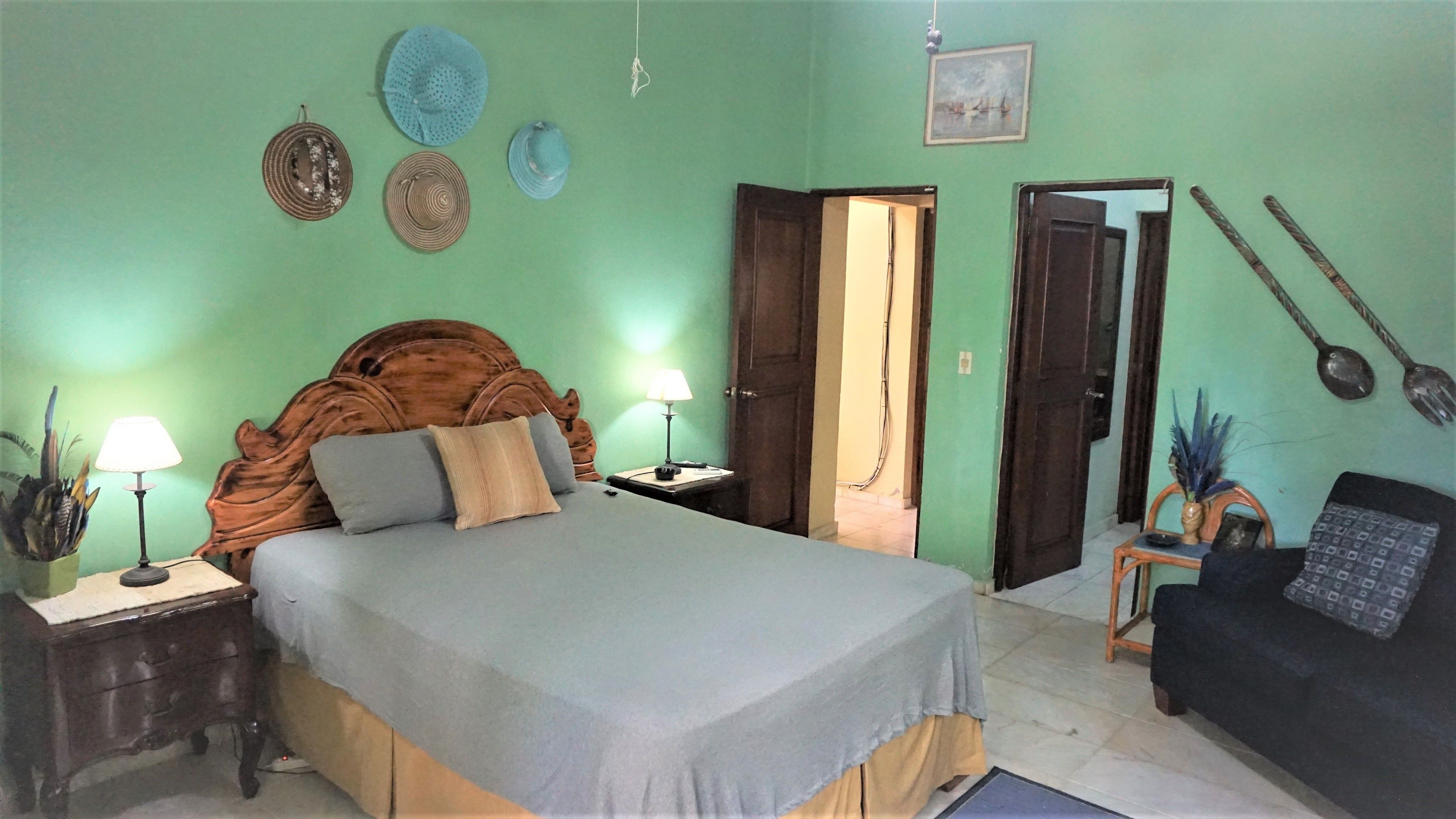 A bedroom with a bed, bedside tables, a lamp, a chair, and a door.