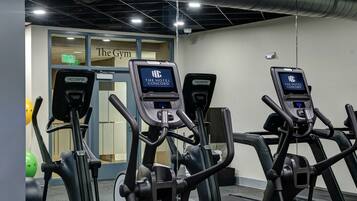 Tres bicicletas estáticas con pantallas digitales en un área de gimnasio de un hotel.