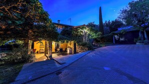 Ein Innenhof mit Steinmauer, einer Holzpergola und einem Essbereich mit Gartenmöbeln.