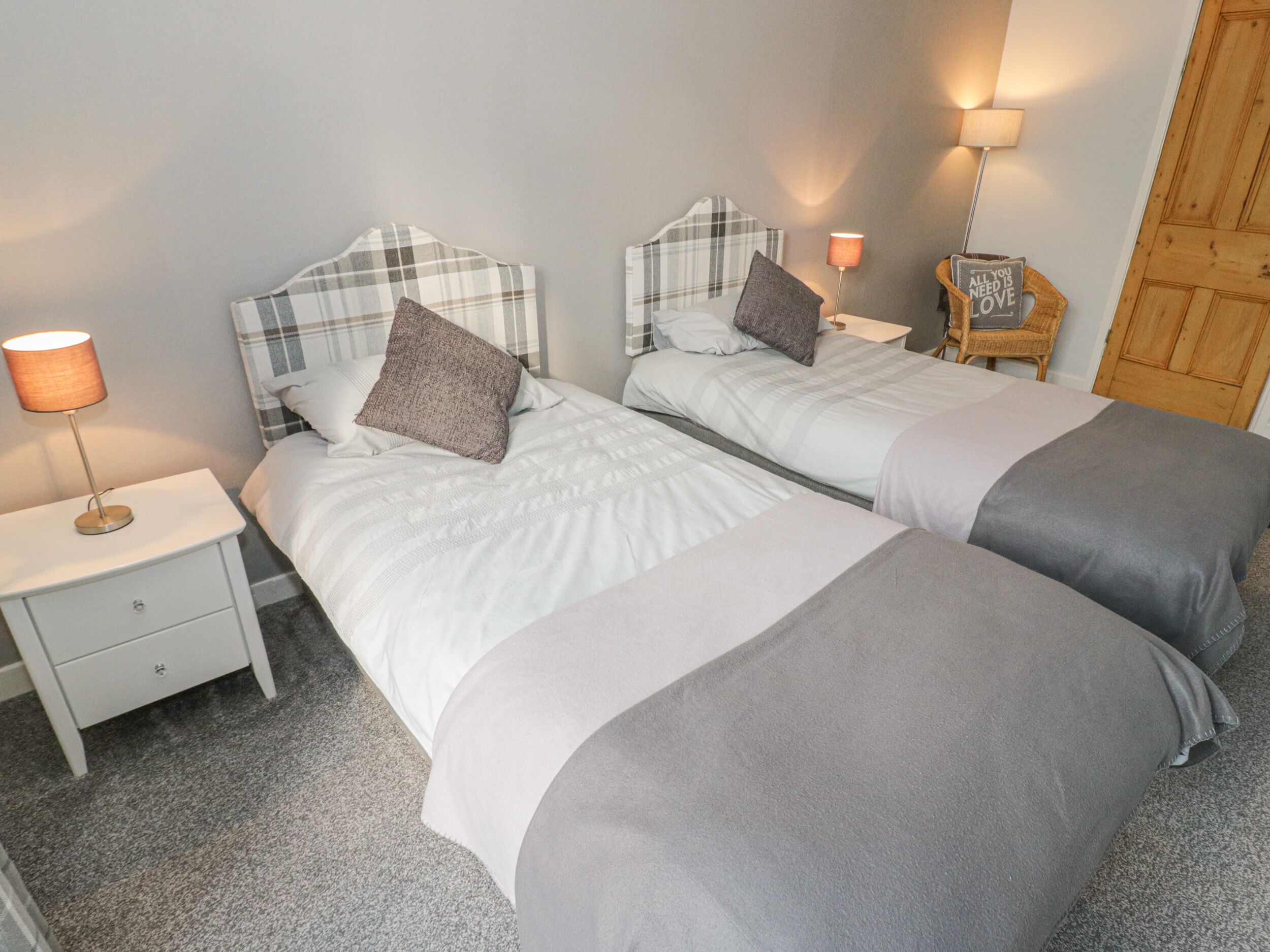 A double room with two beds, each with a headboard, bedside tables, and lamps.