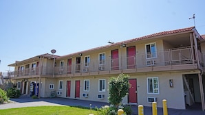 A two-story hotel with balconies, air conditioning units, and a satellite dish. - Budget Inn (Lawndale)
