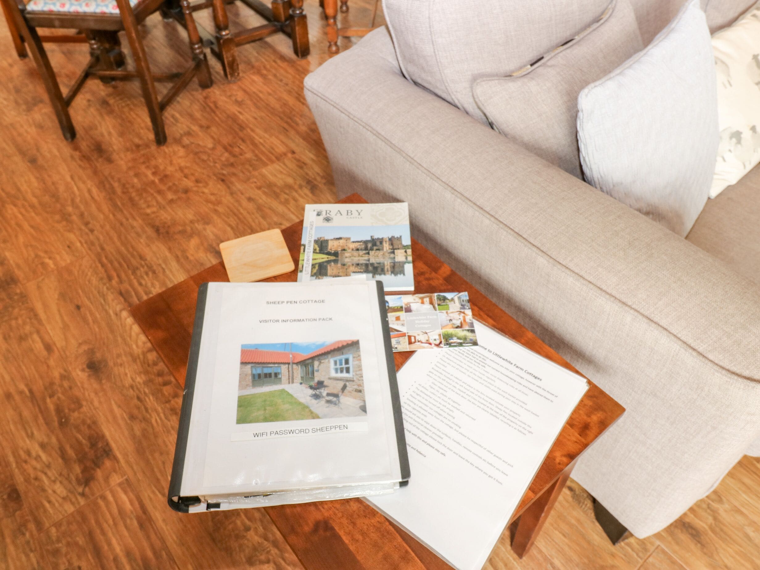 Informationspakke for Sheep Pen Cottage, inklusive en trykt guide og en brochure med et billede af huset.