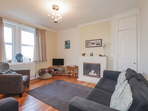 A living room with a fireplace, a television, and a sofa.