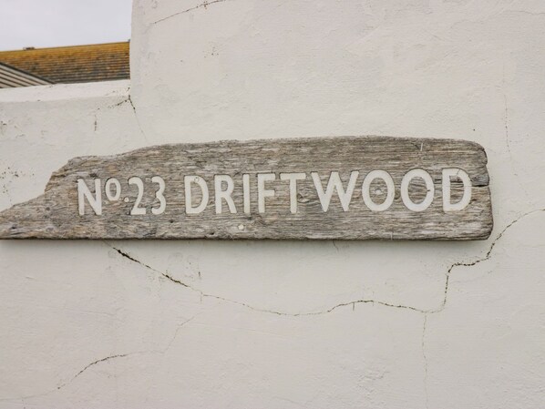 A wooden sign with the text "No.23 Driftwood" mounted on a wall. - Driftwood Cottage Roa Island Piel Island (Barrow-in-Furness)