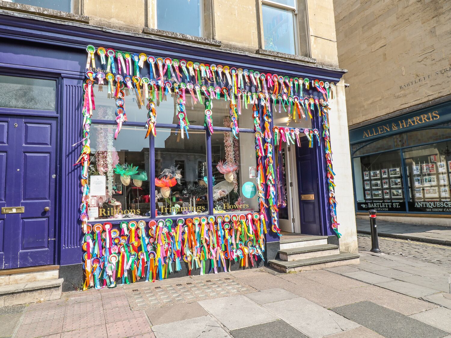 A storefront with a display of colorful ribbons and floral decorations.