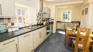 A modern kitchen with a large island, a built-in oven, and a skylight. - Mill Dam Farm Cottage (Lancaster)