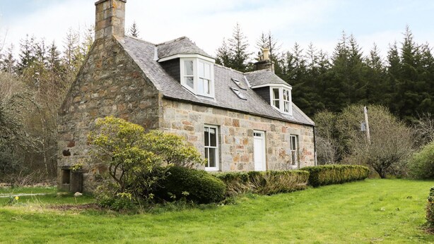 A stone house with a sloped roof, a chimney, and a small porch. - Annfield (Aberlour)