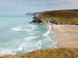 A coastal landscape with a beach, cliffs, and ocean. - Moor View Chapel (Camelford)