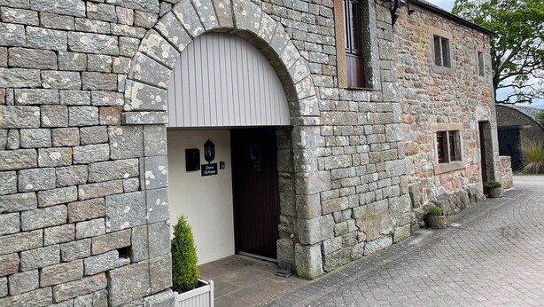 A stone cottage with a white door, a small window, and a sign reading "Clove Cottage". - Clove Cottage (Appleby-in-Westmorland)