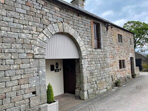 A stone cottage with a white door, a small window, and a sign reading "Clove Cottage". - Clove Cottage (Appleby-in-Westmorland)