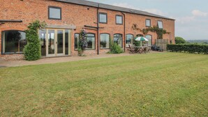 A brick building with large windows and a covered patio area. - The Oaks (Ellesmere)