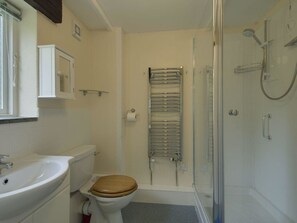 A small bathroom with a toilet, sink, and shower. - The Old Engine House (Bodmin)
