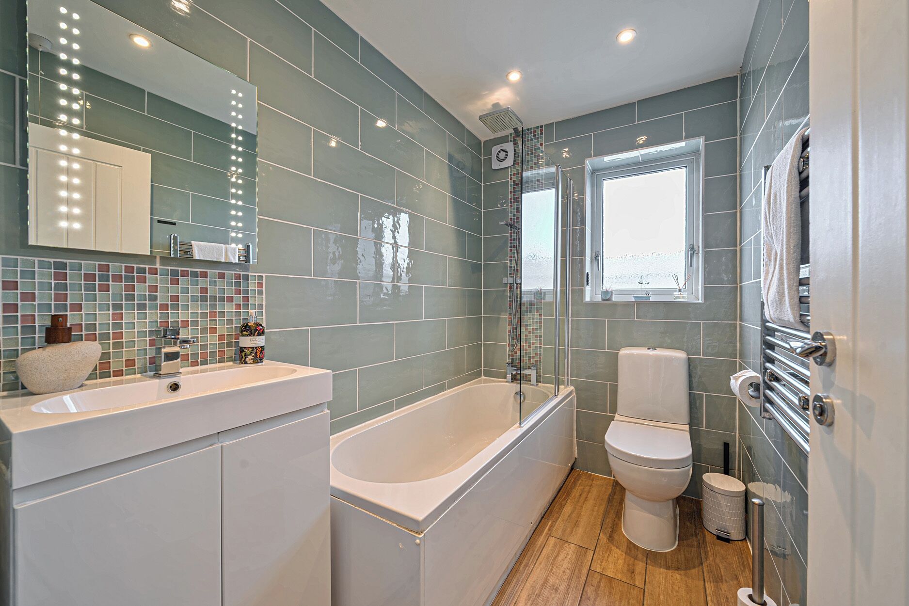 Ein modernes Badezimmer mit Badewanne, Toilette und Waschbecken.