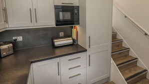 Une cuisine compacte équipée d’un four à micro-ondes, d’un grille-pain et d’un petit placard.