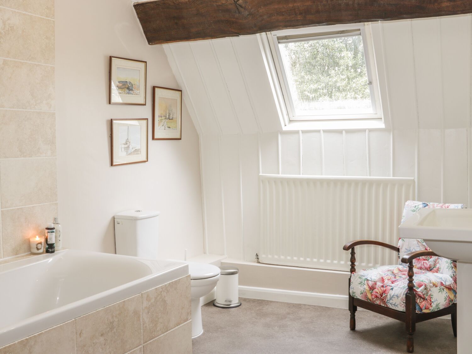 A bathroom with a bathtub, toilet, and window.