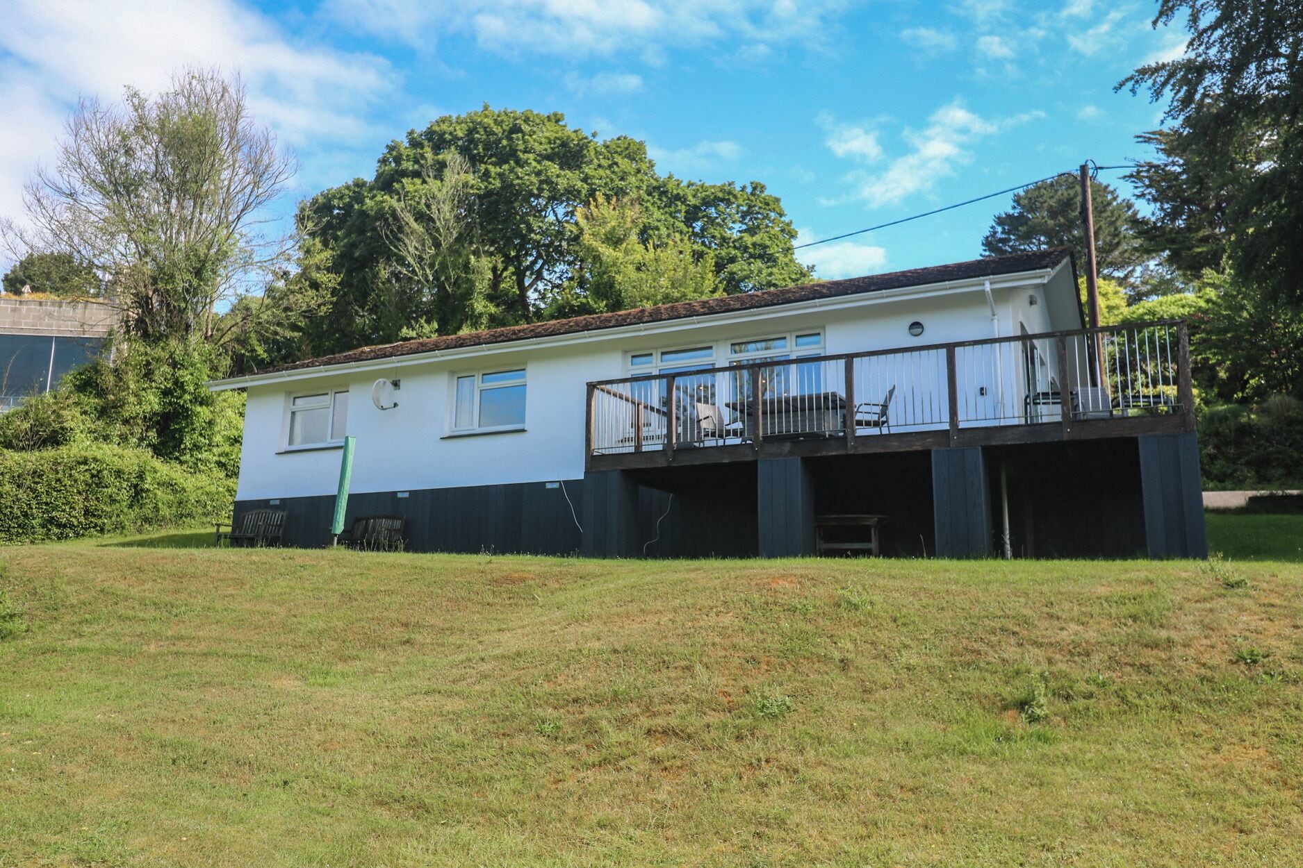 A two-story house with a balcony, a garage, and a grassy yard.