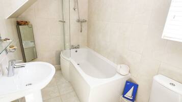 A bathroom with a bathtub, a sink, and a toilet.