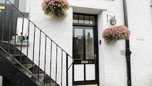 A white building with a black door labeled "8A" and a staircase leading to the entrance. - Chapel Rest (Windermere)