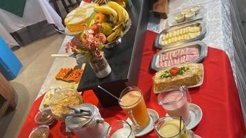 Ein reichhaltiges Buffet mit verschiedenen Speisen und Getränken, darunter Früchte, Gebäck und Aufgüsse.