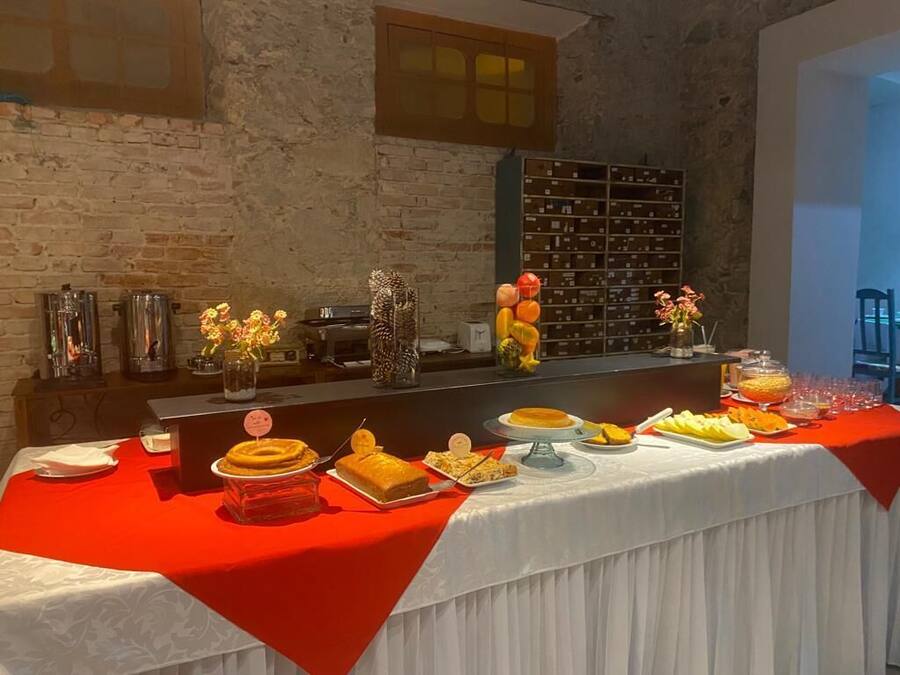 A buffet table with various food items and a decorative vase.