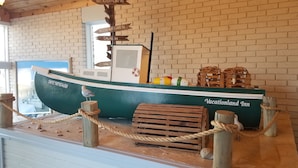 Une maquette de bateau avec un panneau indicateur indiquant les distances vers différents lieux.